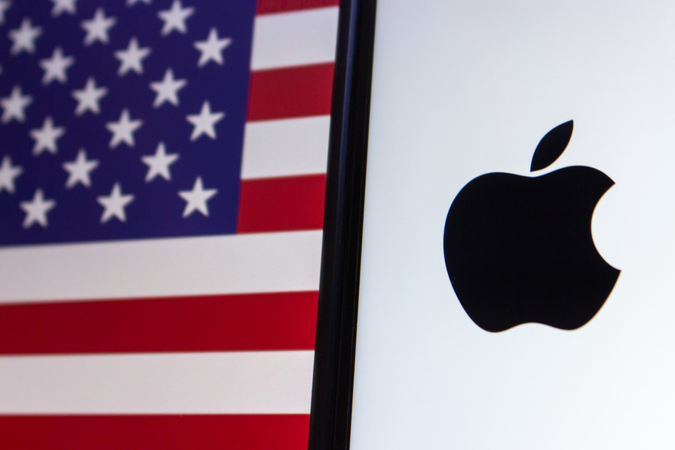 Vancouver, CANADA - Mar 25 2024 : Apple Inc. logo seen on display on USA flag background.